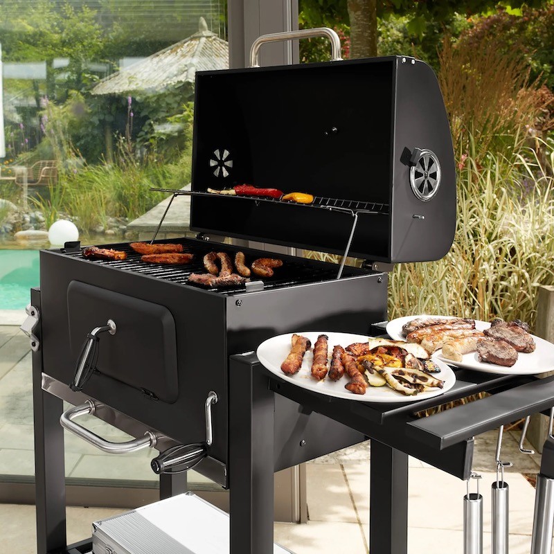 Un barbecue au charbon doté d'une grille à hauteur ajustable pour une cuisson personnalisée