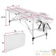 Table de massage pliable en aluminium blanc avec réglage de hauteur et accoudoirs.