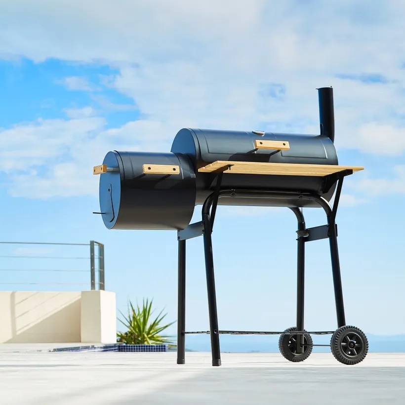 Barbecue à charbon à double cuve équipé d'un thermomètre.